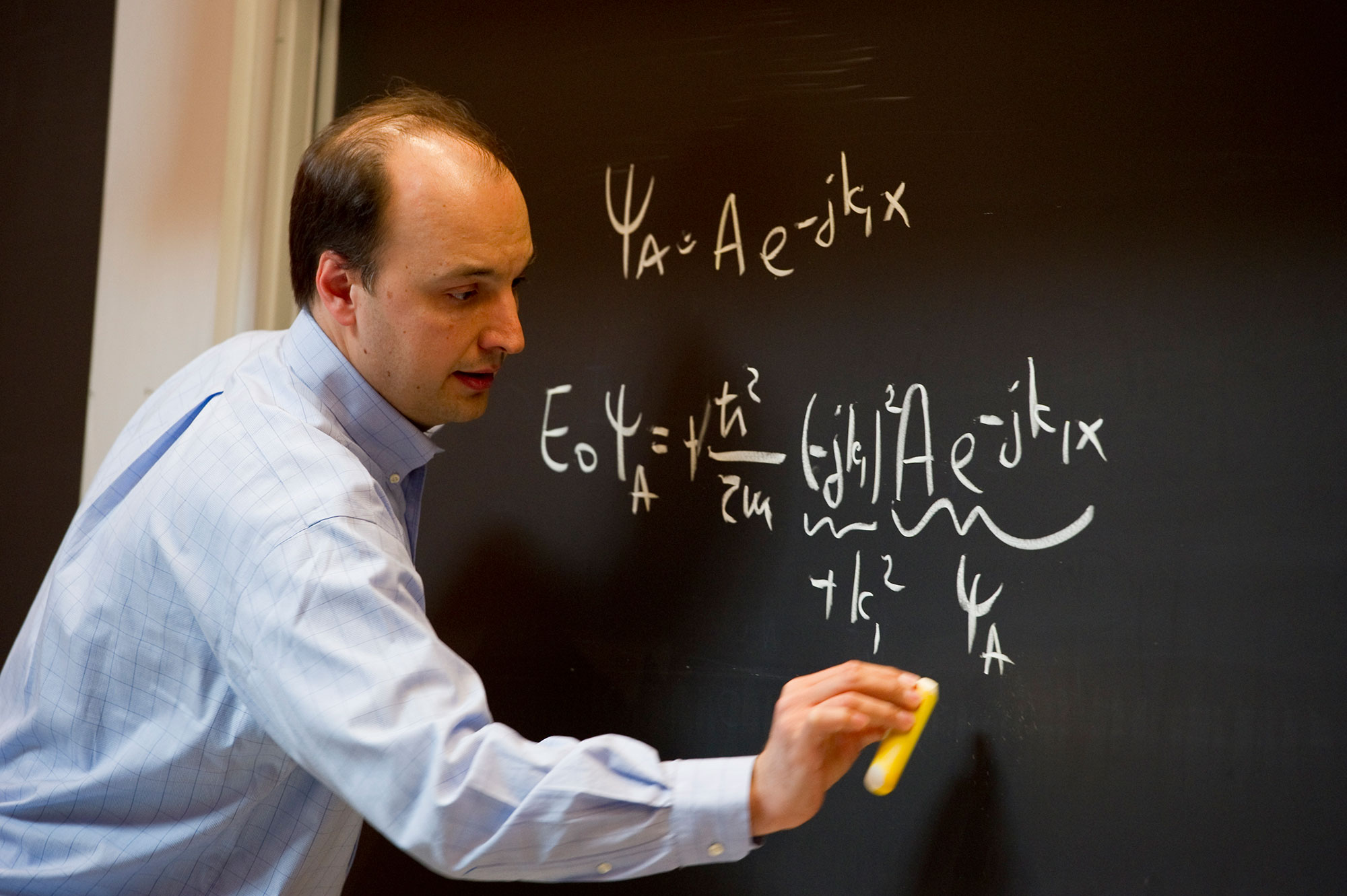 Educator writing on a chalk board